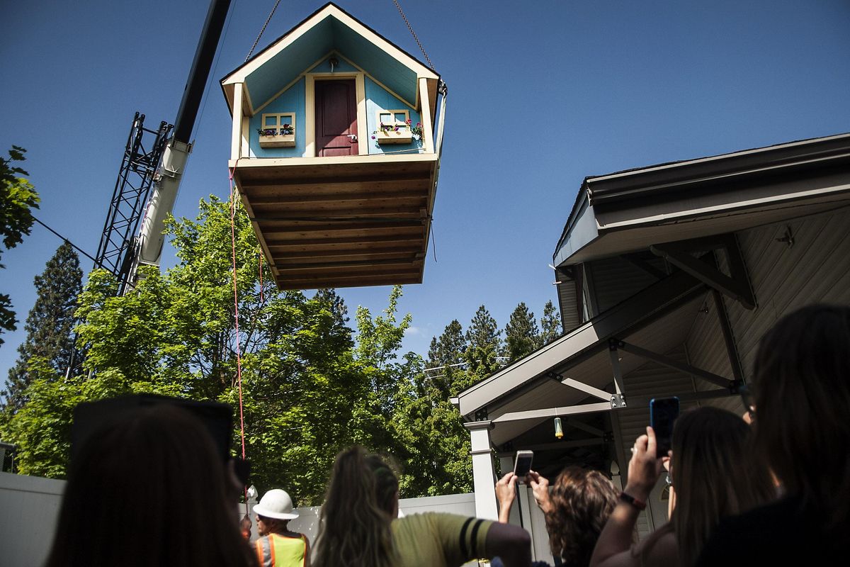The playhouse built by students from Spokane Valley High School is lowered onto the playground at Vanessa Behan Crisis Nursery on Tuesday, June 13, 2017. (Kathy Plonka / The Spokesman-Review)