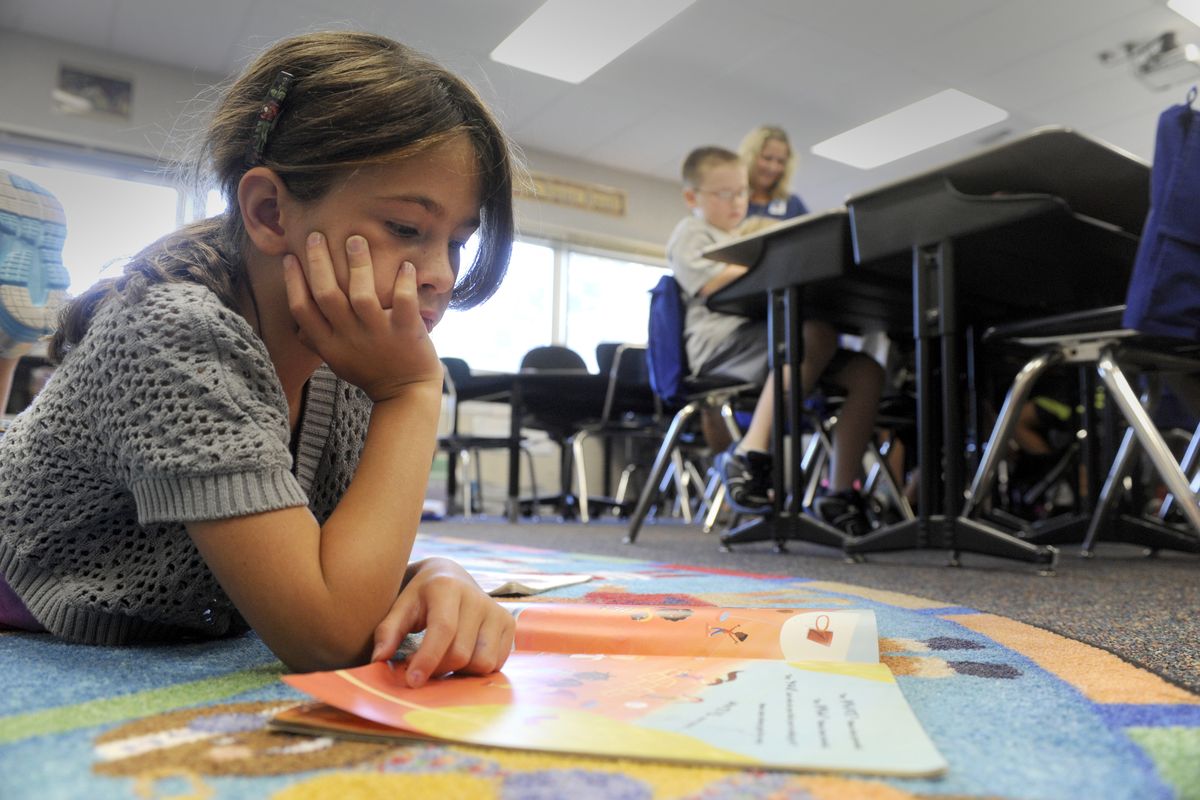 Second-grader Isabella Collier reads quietly in her class at South Pines Elementary School on Wednesday. Isabella is in the Student, Parent Alternative Classroom Experience program, where parents opt in and promise to volunteer and contribute funds to the program. (Jesse Tinsley)