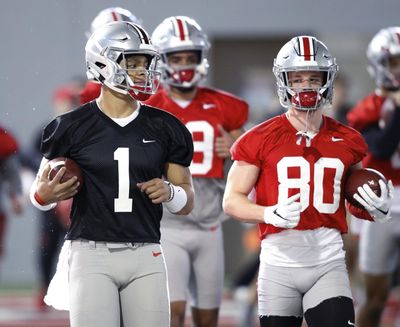 In this March 6, 2019 photo, Ohio State quarterback Justin Fields, left, and wide receiver K.J. Hill run through a drill during the NCAA college football team’s practice in Columbus, Ohio. First-year coach Ryan Day said after the Buckeyes’ spring game he hadn’t decided between Fields and redshirt freshman Matthew Baldwin, who spent much of last season rehabbing a knee injury. (Paul Vernon / Associated Press)