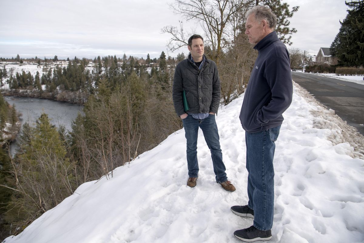 Neighbors Larry Swartz, left, and Mike Etter stand along West Summit Blvd., seen at right, Wednesday, Jan. 22, 2020, on the rim of the Spokane River gorge and talk about the plan to expand the Centennial Trail through their West Central neighborhood. The proposed route would follow Summit Blvd. to Pettet Drive, aka Doomsday Hill, and down to the T.J. Meenach Bridge. The neighbors along Summit believe that creating a new route from the end of Boone Avenue, down to the river and across a new bridge to the former Sisters of the Holy Names property would be a safer, more scenic route than their narrow residential street. (Jesse Tinsley / The Spokesman-Review)