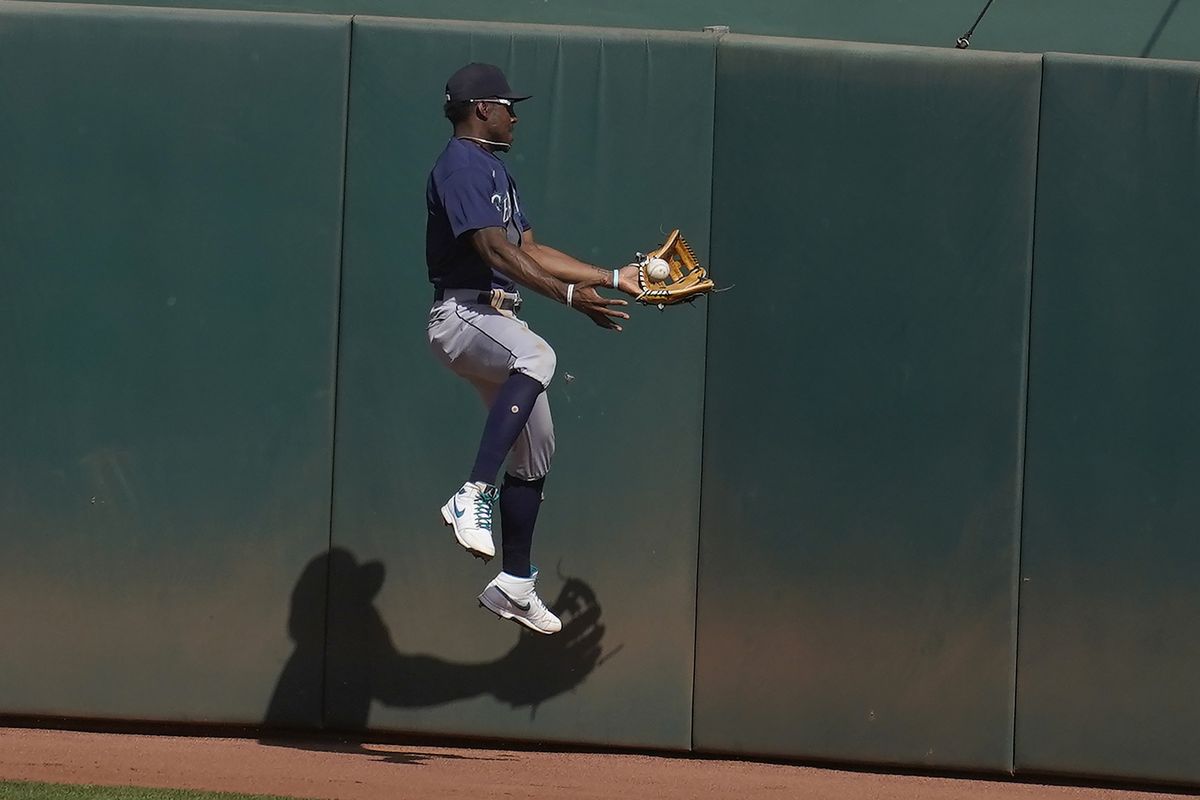 Seattle Mariners center fielder Kyle Lewis cannot catch a two-run double hit by Oakland Athletics’ Mark Canha during the seventh inning of a baseball game in Oakland, Calif., Sunday, Sept. 27, 2020.  (Jeff Chiu)