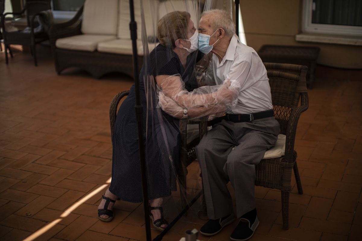 Agustina Cañamero, 81, hugs and kisses her husband Pascual Pérez, 84, through a plastic film screen to avoid contracting the coronavirus at a nursing home in Barcelona, Spain, on June 22, 2020. The image was part of a series by Associated Press photographer Emilio Morenatti that won the 2021 Pulitzer Prize for feature photography.  (Emilio Morenatti)