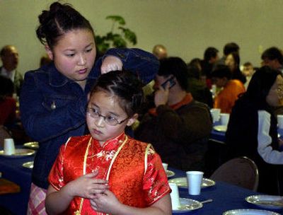 
Mingni Sun fixes her sister Janni's hair during a recent Chinese New Year celebration in Spokane. 
 (File/ / The Spokesman-Review)
