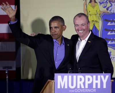 Former President Barack Obama, left, and New Jersey Democratic gubernatorial nominee Phil Murphy stand on stage after Obama gave remarks during a canvassing event for Murphy, Thursday, Oct. 19, 2017, in Newark, N.J. (Julio Cortez / Associated Press)