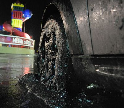 A car with its wheels covered in driveway sealant sits in a parking lot in Harmar, Pa., after exiting the Pennsylvania Turnpike on Tuesday night (Associated Press)