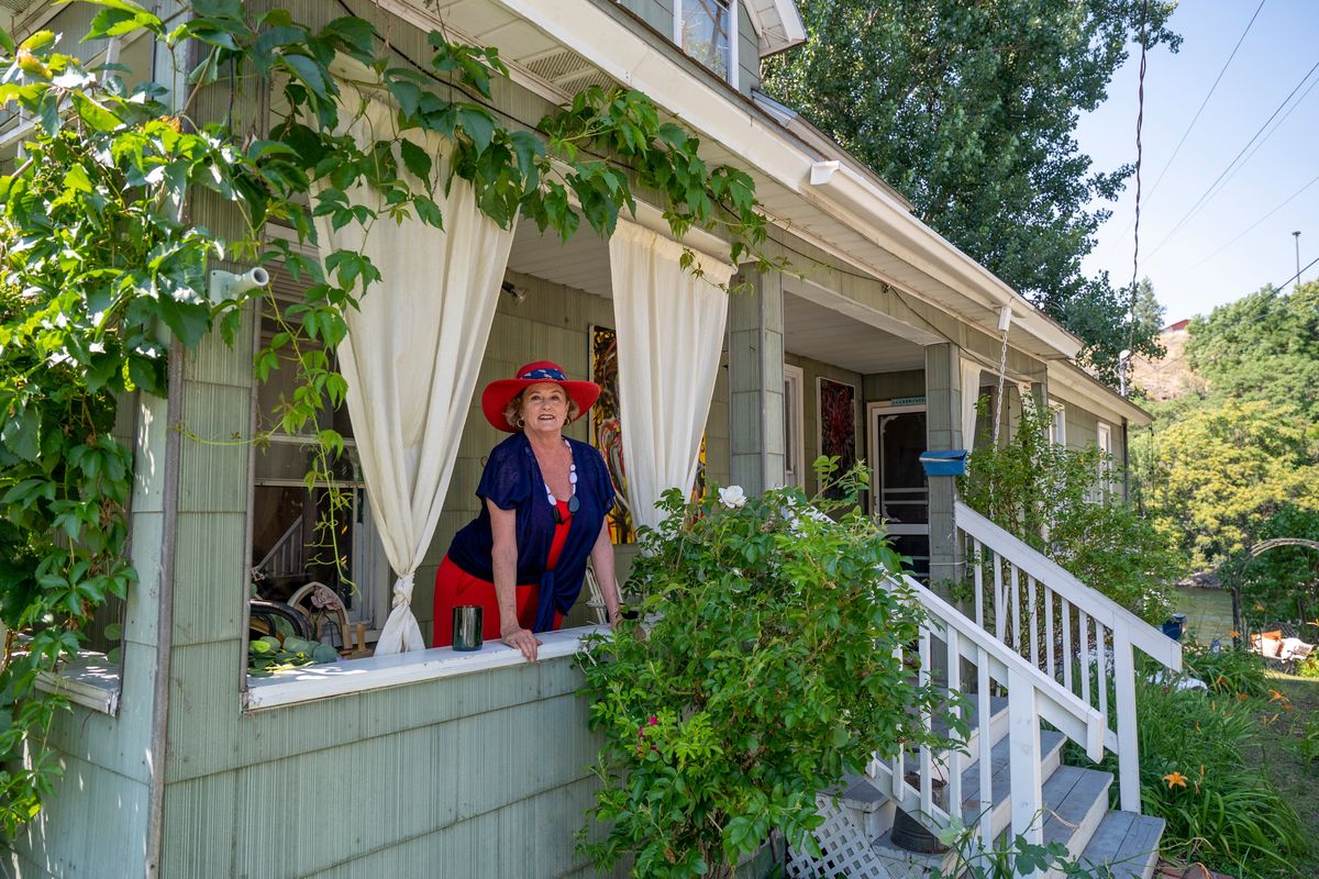Owner Mary Moltke stands on the porch of the house at 301 N. Cedar Street on Tuesday in Peaceful Valley. The house was featured in the movie “Benny and Joon” which was filmed in Spokane in 1993, 30 years ago. The house is one of the few homes that backs up to the Spokane River.  (Jesse Tinsley/THE SPOKESMAN-REVI)
