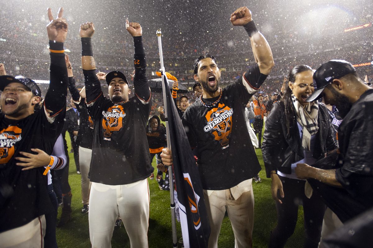 San Francisco Giants right fielder Gregor Blanco, catcher Hector Sanchez, center fielder Angel Pagan and relief pitcher Sergio Romo celebrate on the field following Game 7 of baseball