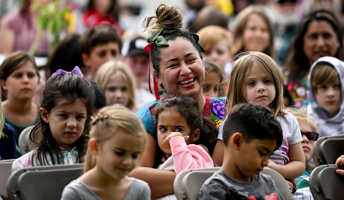 Ruben Trejo Dual Language Academy first-grade teacher Yesenia V’azquezs is surrounded by her students Thursday during the dedication ceremony.  (Kathy Plonka/The Spokesman-Review)