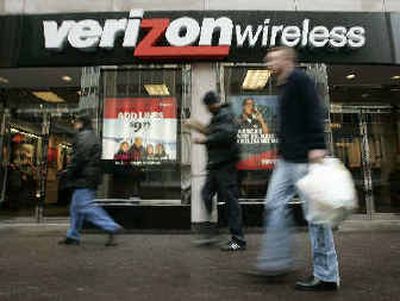 
Pedestrians walk past a Verizon Wireless shop in Washington on Monday. 
 (Associated Press / The Spokesman-Review)