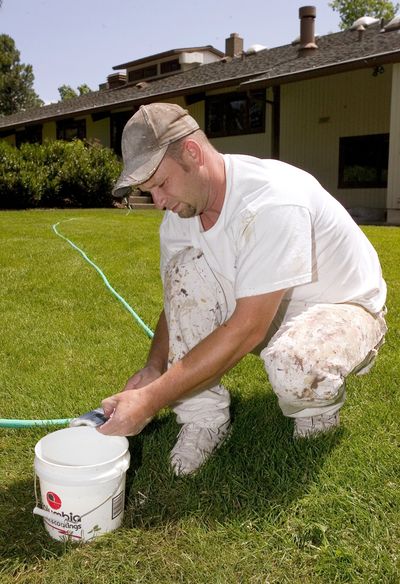 Brian Haning cleans his paintbrush after sprucing up the University of Idaho president’s house in Moscow, Idaho, on Thursday. The residence is getting new flooring and asbestos abatement, among other work.  (Associated Press / The Spokesman-Review)