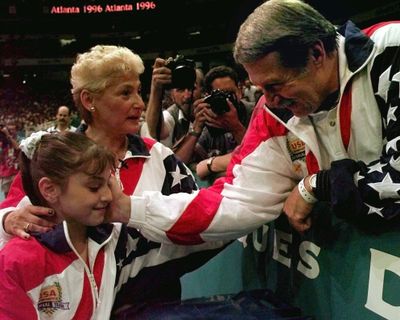 Bela Karolyi congratulates Dominique Moceanu after the United States captured the 1996 Olympic gold medal in the women's team gymnastics competition as coach Martha Karolyi, left, looks on. USA Gymnastics announced Thursday that it was terminating its agreement to have the Karolyi Ranch outside of Huntsville, Texas, serve as the National Training Center for the women’s elite program. (AMY SANCETTA / Associated Press)