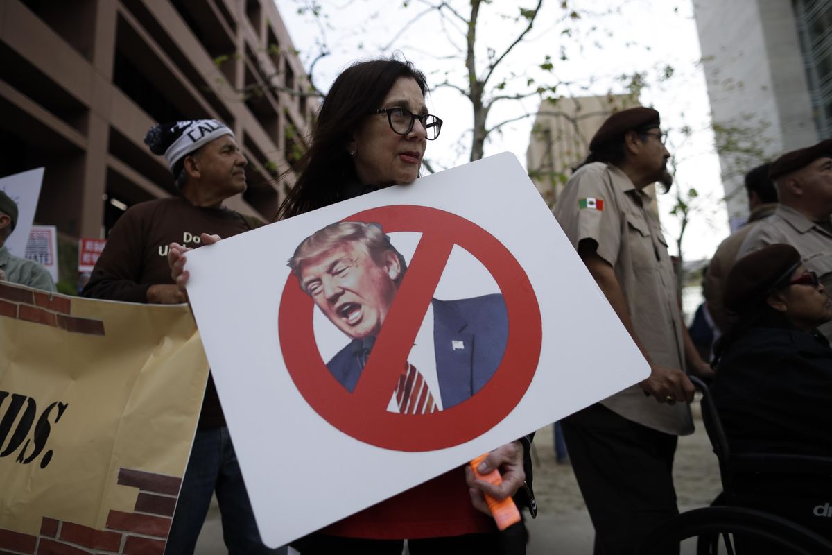 Jill Green holds a sign during a rally against a scheduled upcoming visit by President Donald Trump, Monday, March 12, 2018, in San Diego. Trump is scheduled to visit San Diego, Tuesday, setting foot in California for his first time as president. (Gregory Bull / AP)