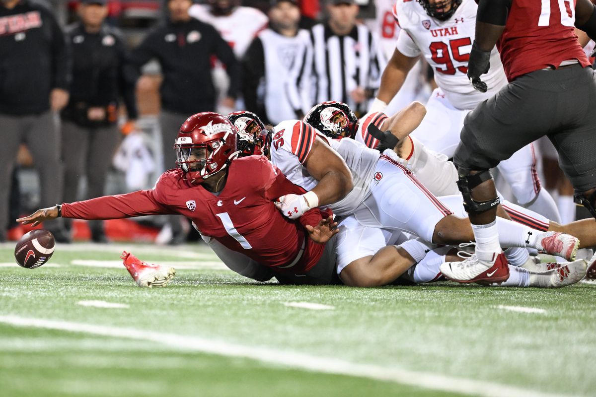 Washington State Cougars quarterback Cameron Ward (1) loses control of the ball as he is brought down by Utah Utes defensive tackle Junior Tafuna (58) as a Utah shoe goes flying in the chaos during the first half of a college football game on Thursday, Oct. 27, 2022, at Martin Stadium in Pullman, Wash.  (Tyler Tjomsland/The Spokesman-Review)