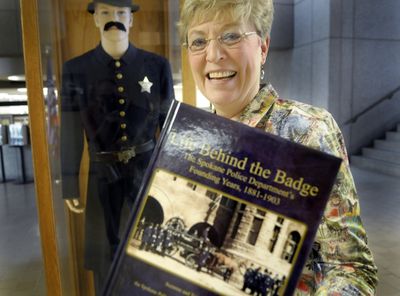 Susan S. Walker, secretary/treasurer of the Spokane Law Enforcement Museum, holds a new book detailing the history of the Spokane Police Department. The book, “Life Behind the Badge,” was written by Suzanne and Tony Bamonte, with help from the SPD History Book Committee.  (Christopher Anderson / The Spokesman-Review)