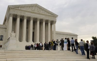 People stand in line to attend the opening session of the Supreme Court in Washington on Monday.  (Associated Press / The Spokesman-Review)