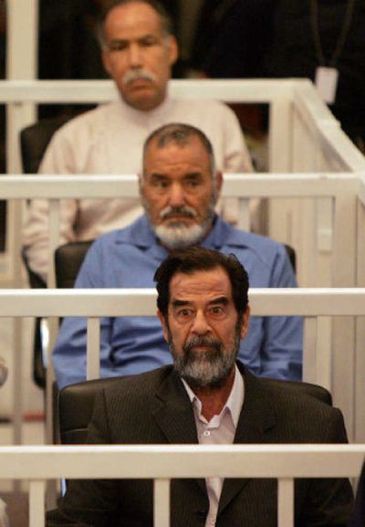 
Saddam Hussein, front, Abdullah Kazim Ruwayyid, center, and Barzan Ibrahim sit in the courtroom as their trial gets under way in Baghdad's heavily fortified Green Zone on Wednesday. Saddam pleaded not guilty to charges of murder and torture. 
 (Associated Press / The Spokesman-Review)