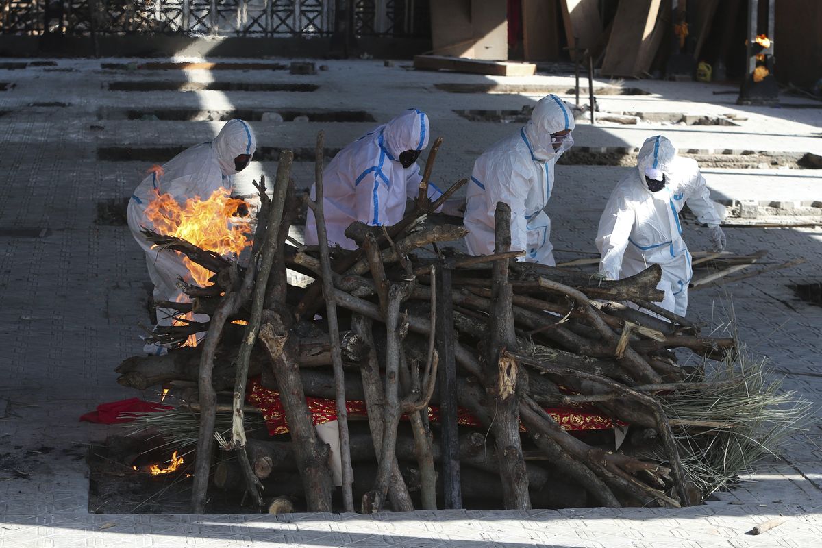 Family members of a person who died due to COVID-19 perform the last rites at a crematorium in Jammu, India, Monday, April 26, 2021.  (Channi Anand)