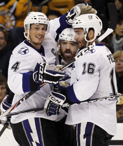Brett Clark, center, is congratulated by Tampa Bay teammates Vincent Lecavalier (4) and Teddy Purcell after Clark scored. (Associated Press)