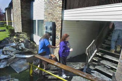 
Lora Ard, left, reaches out to her sister Tracy Charlton as they try to find what is left from Charlton's burned-out apartment Monday morning. The fire in the Regal Arms Apartment complex destroyed her apartment but she was able to get her asthmatic son out before they were overcome by smoke. 
 (Christopher Anderson/ / The Spokesman-Review)
