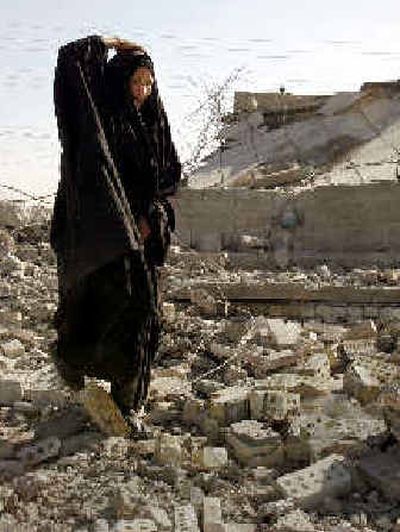 
A woman walks amid the rubble of a government building in Baghdad that insurgents bombed on Sunday. 
 (Associated Press / The Spokesman-Review)