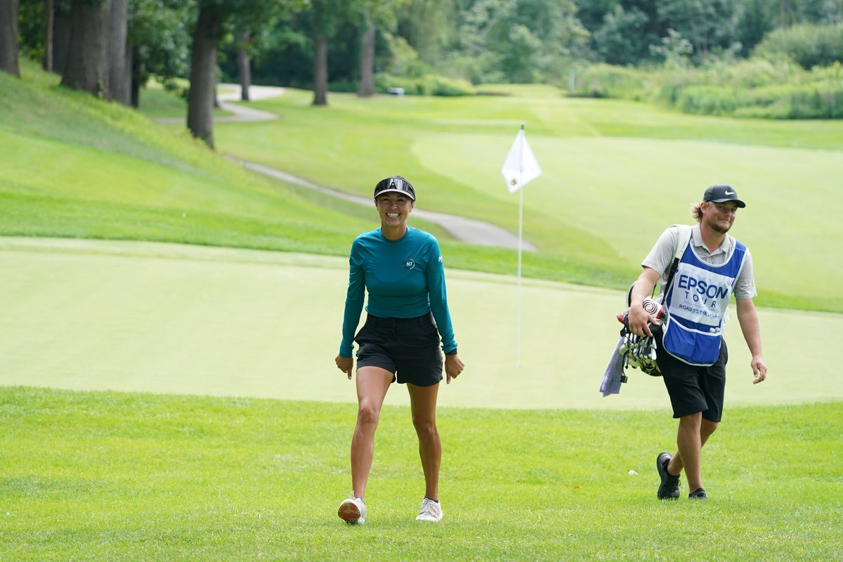 Caldwell, Idaho, native Gabby Lemieux smiles with husband/caddie Jared while walking off a green at Circling Raven Golf Club in Worley.  (Courtesy Epson Tour)