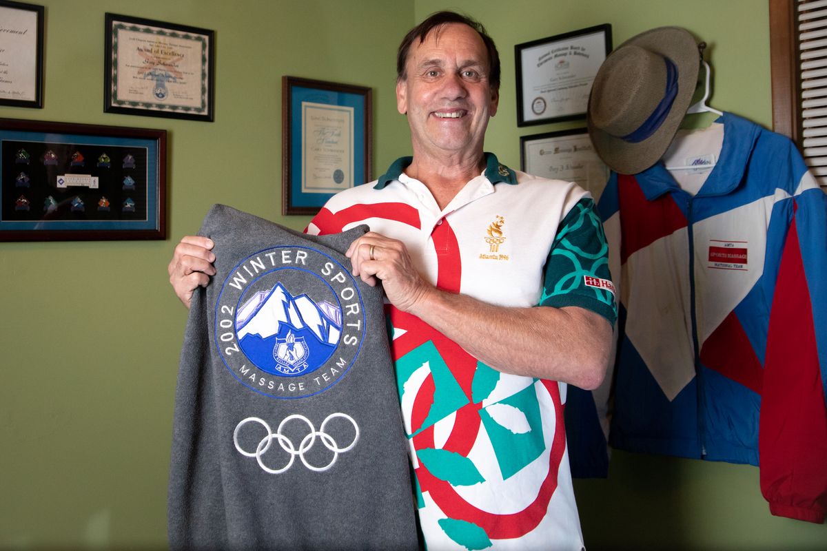 Gary Schwander stands for a photo in his original 1996 Olympic uniform shirt from the Atlanta Games, when he was selected as one of 130 massage therapists for the inaugural Olympics where massage therapists were considered official staff. Schwander’s 32 years of sports massage therapy continued through a Winter Olympics, and he is an instructor at Therapeutic Connections School of Massage in Spokane and runs a practice out of his Spokane Valley home. (Libby Kamrowski/The Spokesman-Review)