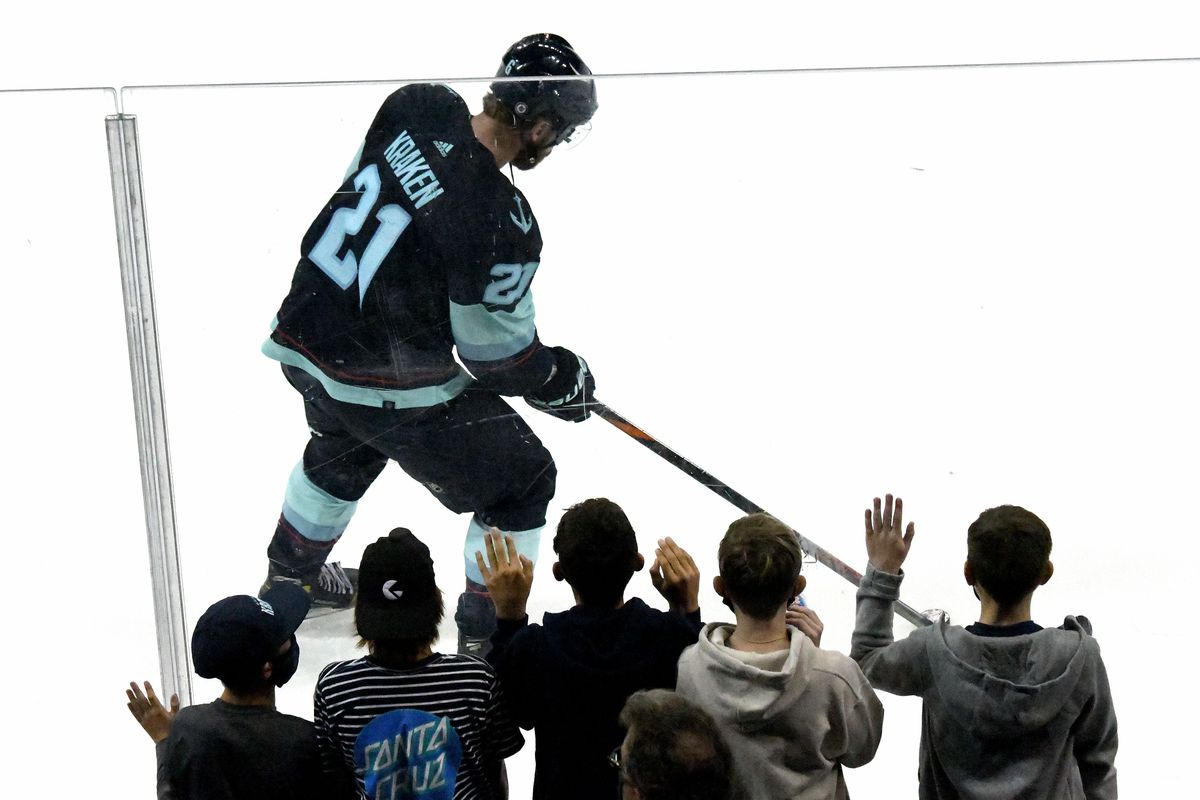 Kids watch as Carson Soucy (21) of the Seattle Kraken glides past during the exhibition game against the Vancouver Canucks at the Spokane Arena on Sunday, Sept. 26, 2021.  (Kathy Plonka/The Spokesman-Review)