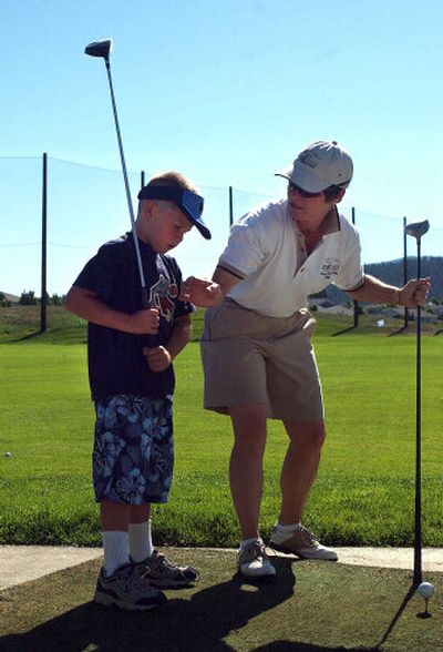 
Trailhead golf professional Mollie Thola works with Brandon Carlson, 7, on his swing at the Trailhead Golf Course driving range in Liberty Lake during the junior golf program.
 (Liz Kishimoto / The Spokesman-Review)