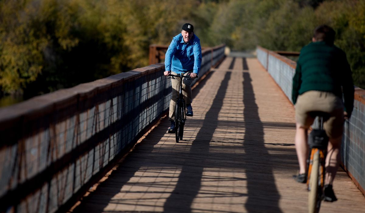Bob Whittaker, left, rides his bike with Brian Carpenter on the The Ferry County Rail Trail on Friday, Sept. 28, 2018, outside Republic, Wash. (Tyler Tjomsland / The Spokesman-Review)