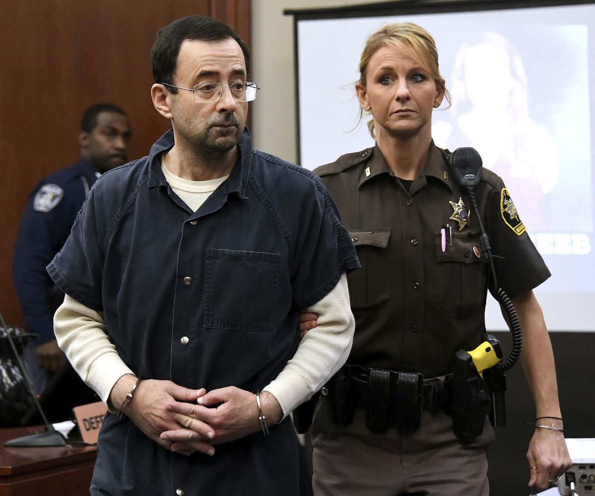 Larry Nassar is escorted into the courtroom, Friday, Jan. 19, 2018, in Lansing, Mich., during the fourth day of sentencing for former sports doctor Larry Nassar, who pled guilty to multiple counts of sexual assault. (Dale G. Young / Detroit News via AP)