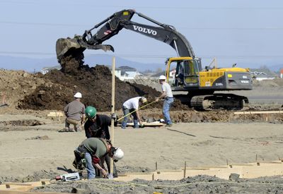 Scott Luckenbach, lower front, and Wes Weaver, of Vandervert Construction, work on footings, while plumbers work on pipes and excavation crews clear the parking lot at the new movie complex being built on Highway 2 near Airway Heights. (Dan Pelle / The Spokesman-Review)