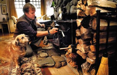 
Russ Page works with his woodstove at his Ashland, Ore. home. Woodstoves have become more efficient and wood heat is once again gaining popularity. 
 (Associated Press / The Spokesman-Review)