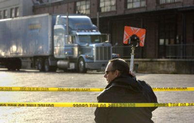 
Spokane police Officer Dave Grenon surveys the scene Wednesday at Riverside and Division in Spokane, where a truck driver died after trying to elude police during an early-morning chase. 
 (Dan Pelle / The Spokesman-Review)