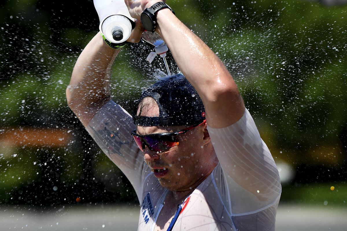 A competitor dumps icy water over his head at an aid station during the marathon portion of the 2021 Coeur d