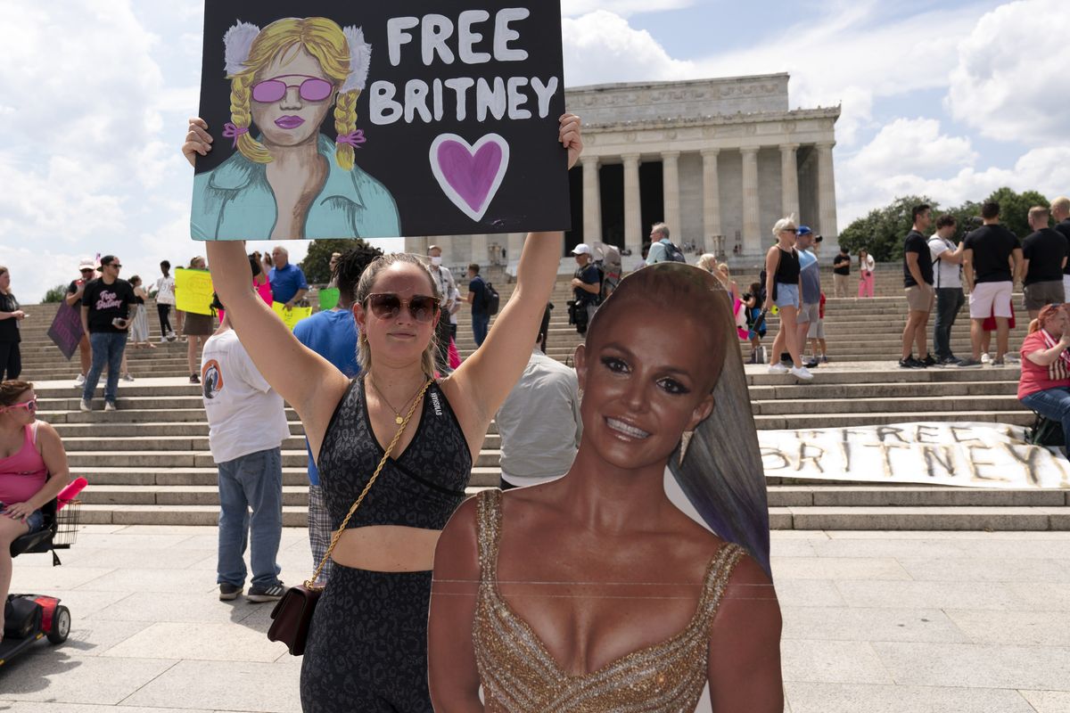 FILE - In this July 14, 2021 file photo Maggie Howell supporter of pop star Britney Spears protests next to a Britney Spears cardboard cutout at the Lincoln Memorial, during the "Free Britney" rally, in Washington. Spears