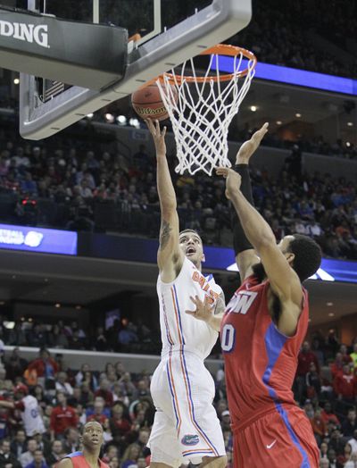 Florida’s Scottie Wilbekin, left, goes up for two of 23 points to lift the Gators into the Final Four.
