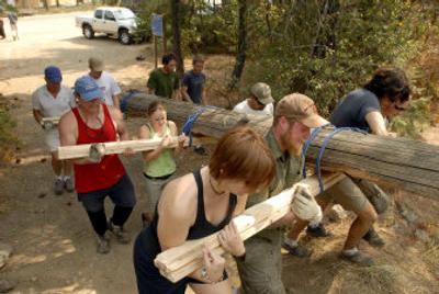 
 Volunteers haul a split log to where it will line a trail at Q'emiln Riverside Park in Post Falls on Saturday. It was part of the Adopt-a-Crag cleanup, with climbers and other outdoor enthusiasts participating in litter pickup, trail improvements and rock face cleanup. 
 (Jesse Tinsley / The Spokesman-Review)