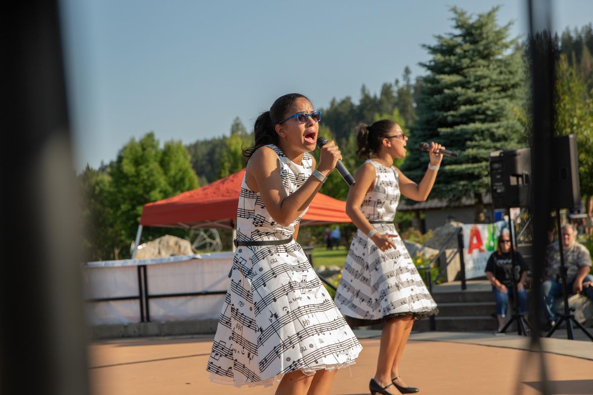 Kelsey Weddle, left, and Marissa Weddle of performing duo the Weddle Twins sing at the Riverstone Summer Concert series on July 5. The 26-year-old twins sing standards from the 1920s through the 1960s, with a few recent show tunes thrown in. (Libby Kamrowski / The Spokesman-Review)