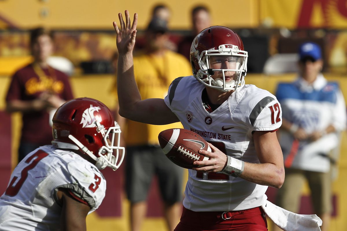 Washington State’s Connor Halliday fakes the pass as he gets ready to hand the ball off to Carl Winston in second half. (Associated Press)