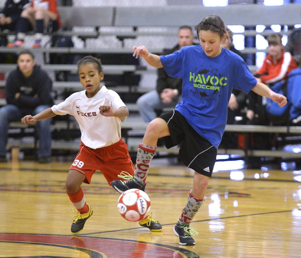 At the Snowball Shootout at the HUB sports center, Amaree Moore, left, and Jordy Newman, both 10 years old, play futsal, an indoor version of soccer, Saturday, Dec. 28, 2013.  Futsal uses a ball with less bounce. (Jesse Tinsley / The Spokesman-Review)