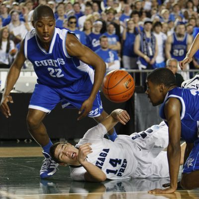 Curtis’ Patrick Cooks, left, leans over a sprawled TJ Bracey of Gonzaga Prep as James Cooks defends. (Associated Press)
