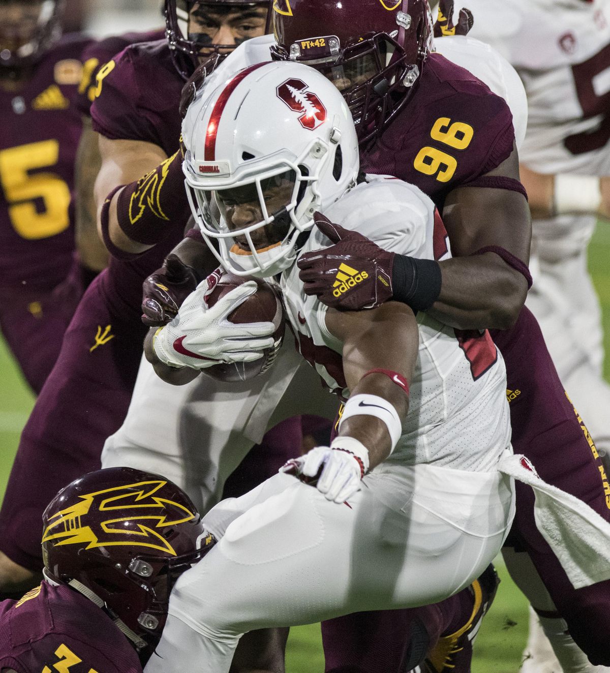 Stanford’s Bryce Love gets wrapped up by Arizona State’s Jalen Bates during the first half  last Thursday in Tempe, Ariz. (Darryl Webb / AP)