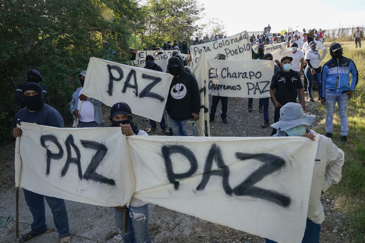 Residents of Aguililla and other nearby communities who are fed up with the army’s strategy of simply separating the Jalisco and the Michoacan-based Viagras gangs, march against roadblocks in Loma Blanca, Mexico, Tuesday, Nov. 16, 2021. The army policy effectively allows the Viagras, best known for kidnapping and extorting money, to set up roadblocks and checkpoints that have choked off all commerce with Aguililla. Limes and cattle heading out, or supplies heading in, must pay a war tax to the Viagras.  (Eduardo Verdugo)