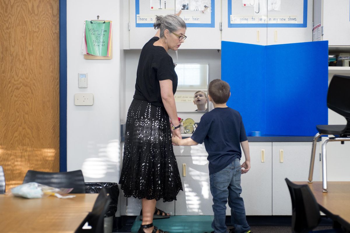 Kindergarten teacher Elizabeth Coyote walks around her classroom with Gabe Zobrist, 5, and looks at letters he will need to study as part of his homework, Thursday, Aug. 31, 2017, at Wilson Elementary School in Spokane. (Jesse Tinsley / The Spokesman-Review)