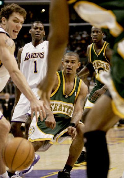 
Seattle's Earl Watson passes the ball around Los Angeles' Luke Walton. 
 (Associated Press / The Spokesman-Review)