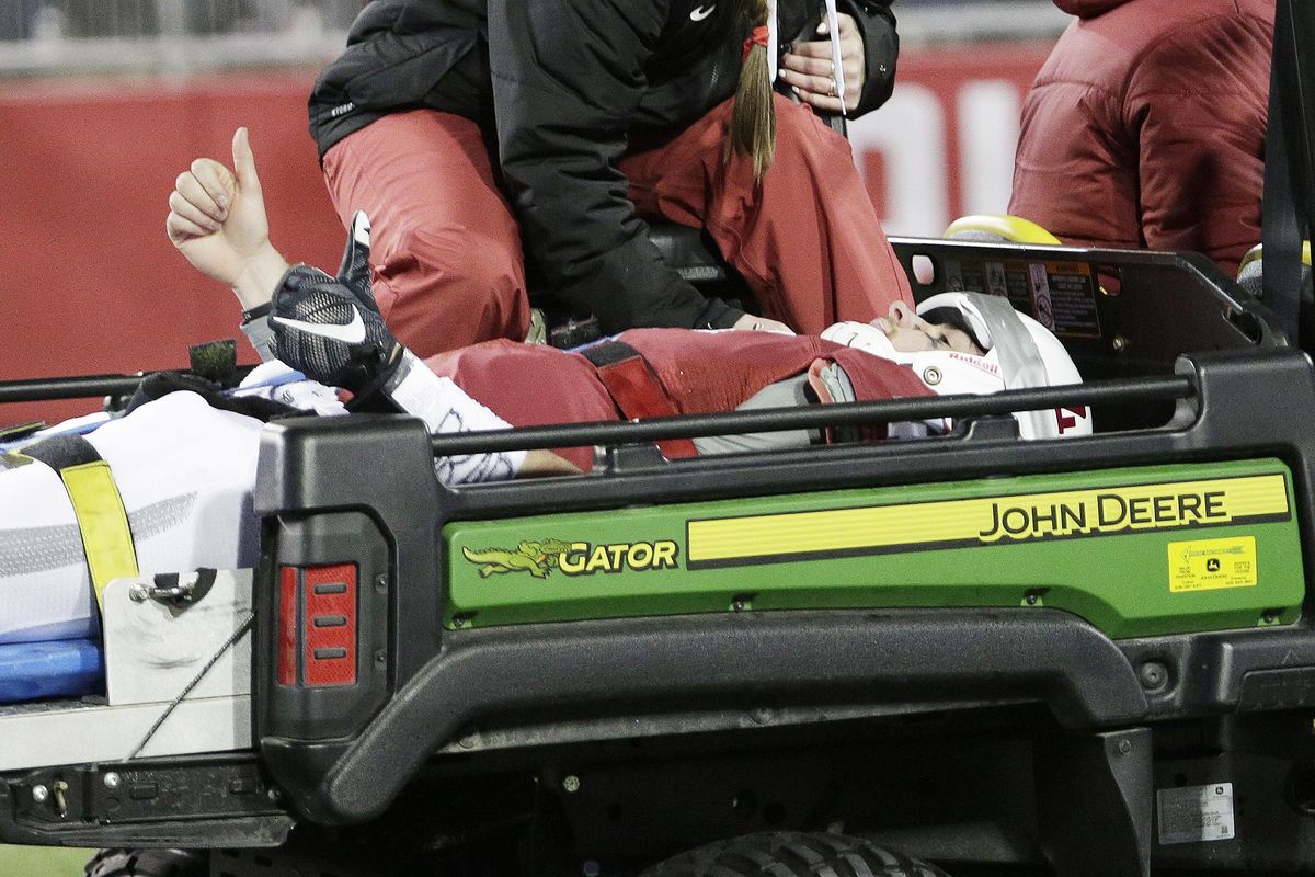 Cougars quarterback Luke Falk  gives fans a thumbs up as he’s carted off the field.