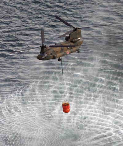 Japan's Self-Defense Forces's helicopter scoops water off Japan's northeast coast on its way to the Fukushima Dai-ichi nuclear power plant in Okumamachi Thursday morning, March 17, 2011. Helicopters are dumping water on a stricken reactor in northeastern Japan to cool overheated fuel rods inside the core. (Kenji Shimizu / Shiyo)