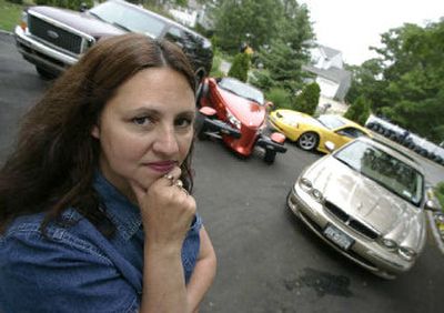 
Melissa Senatore stands in the driveway of her home, in Riverhead, N.Y., with four of the five vehicles her family owns. Senatore was paying more than $14,000 a year for auto insurance on the cars, but has gotten the bill down. 
 (Associated Press / The Spokesman-Review)