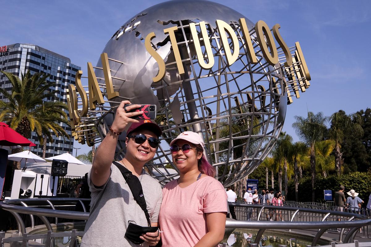 People take photos at Universal Studios on June 15 in Universal City, Calif. On Tuesday, California lifted most of its COVID-19 restrictions and ushered in what has been billed as the state’s “Grand Reopening.” (Ringo H.W. Chiu)
