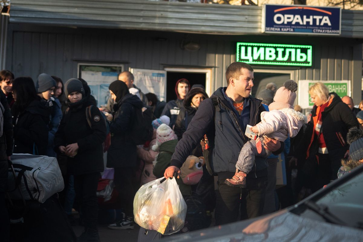 A man carries a child near the Polish-Ukrainian border on March 12, 2022.  (Eli Francovich/The Spokesman-Review)